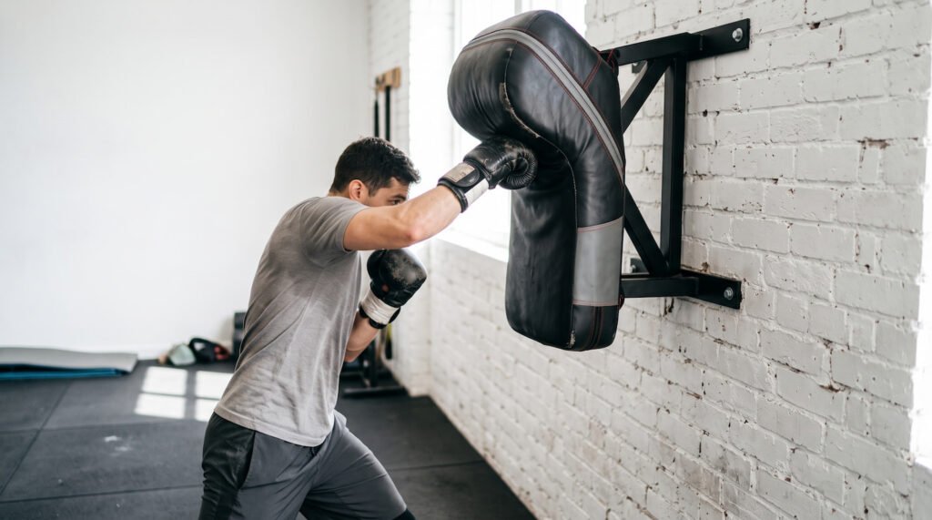 Persona practicando uppercuts en un saco de boxeo de pared